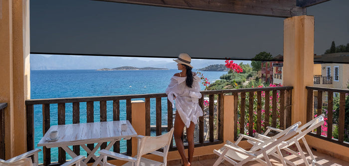 Woman enjoying the ocean view on a terrace with outdoor shades