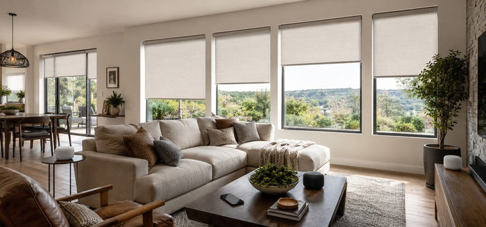  Modern living room with motorized roller shades, smart speakers, and a smartphone showing a connected smart home setup.