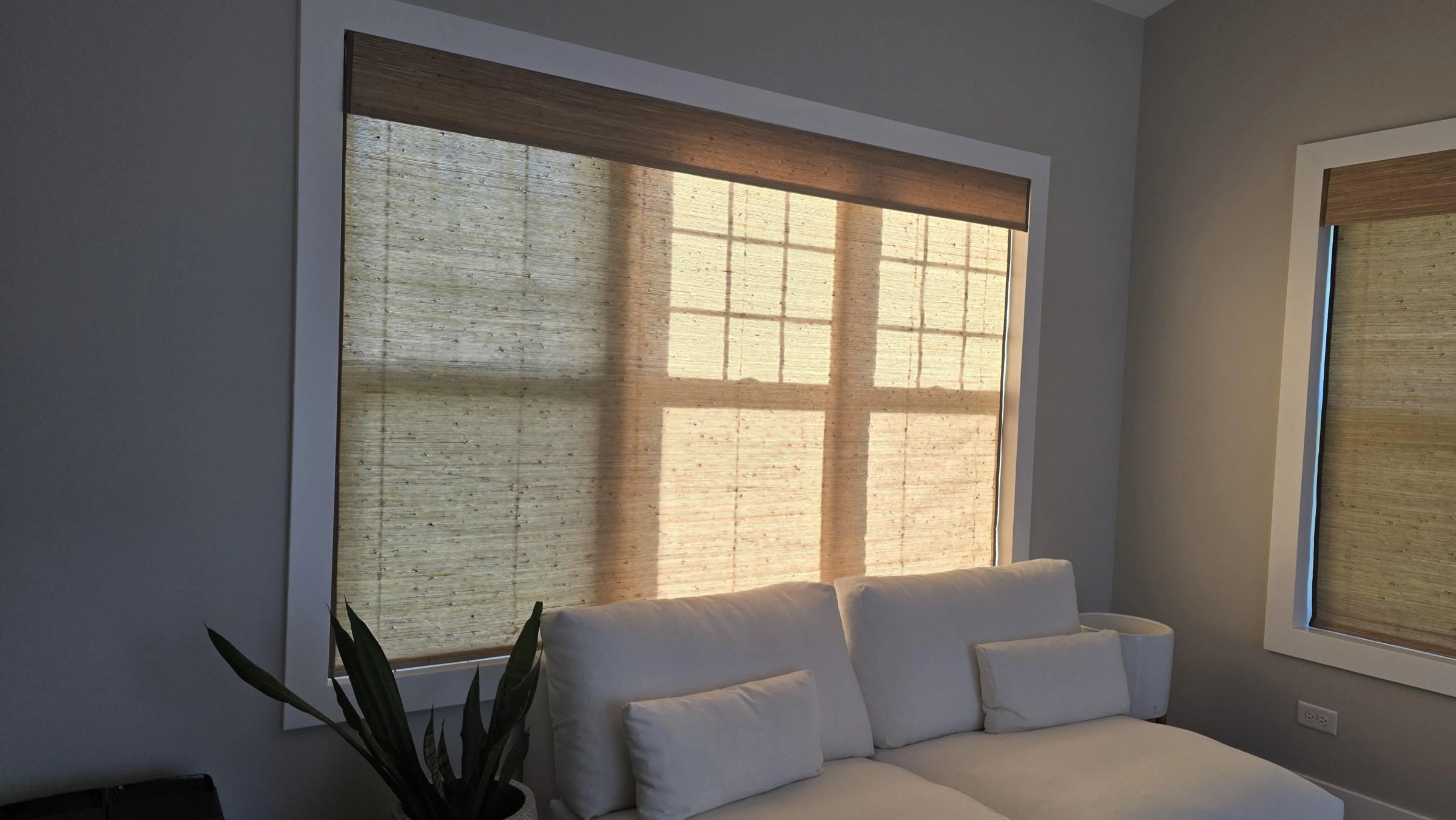 Closed woven wood shades casting warm window shadows